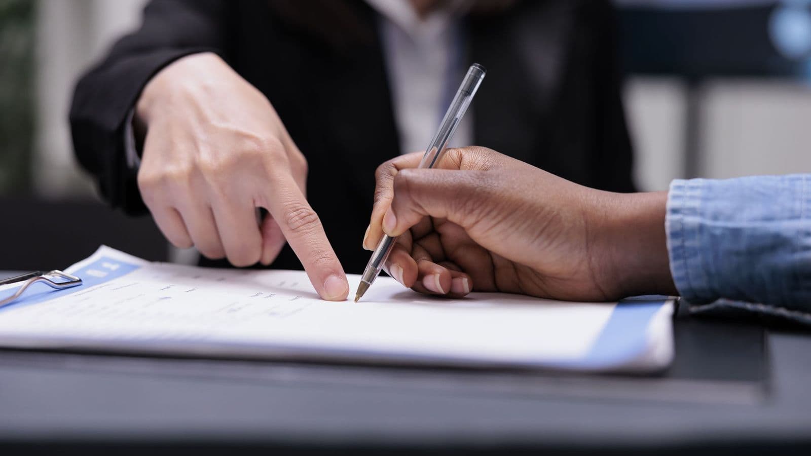 Two people reviewing and signing a contract